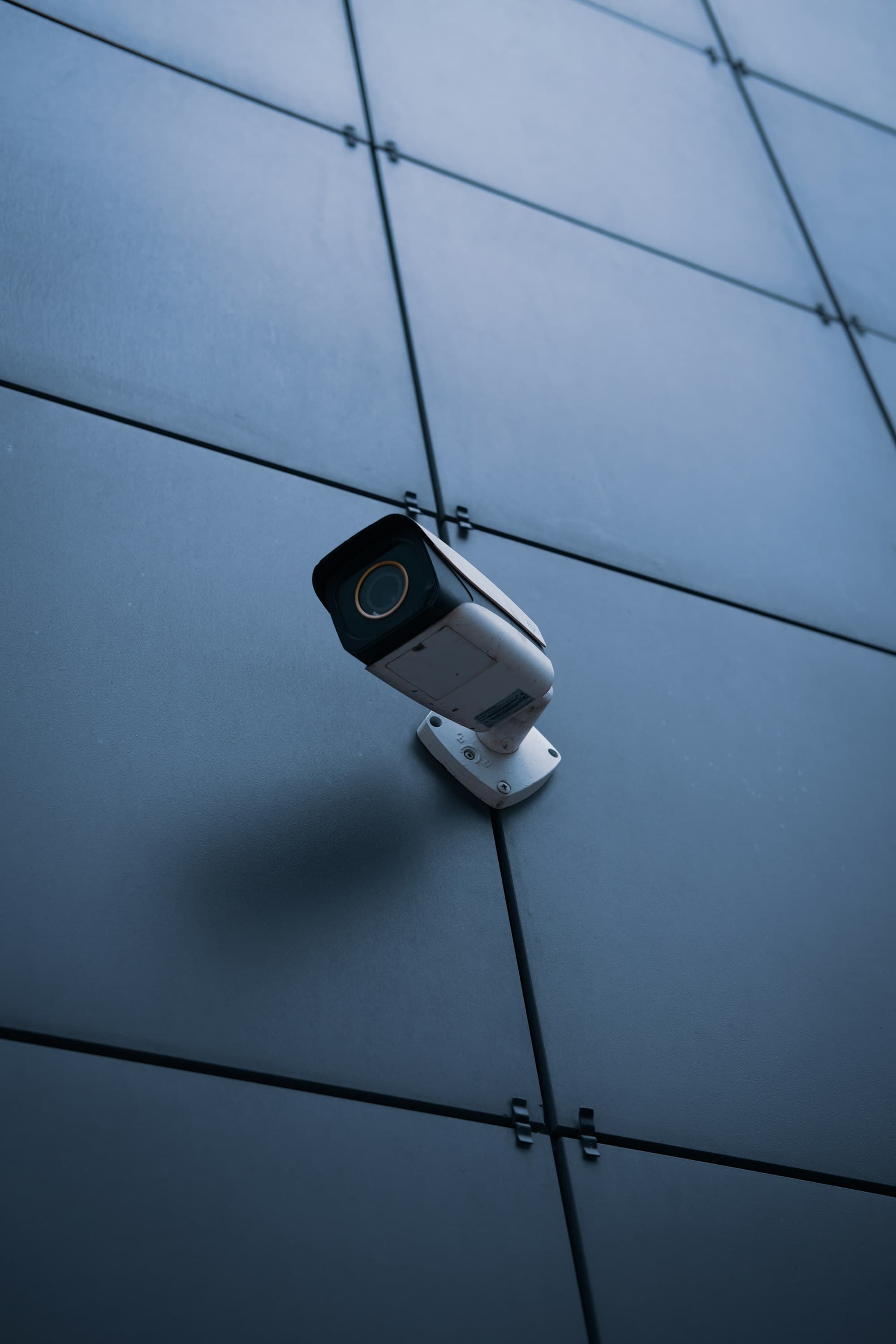 Security camera mounted on a dark blue building wall