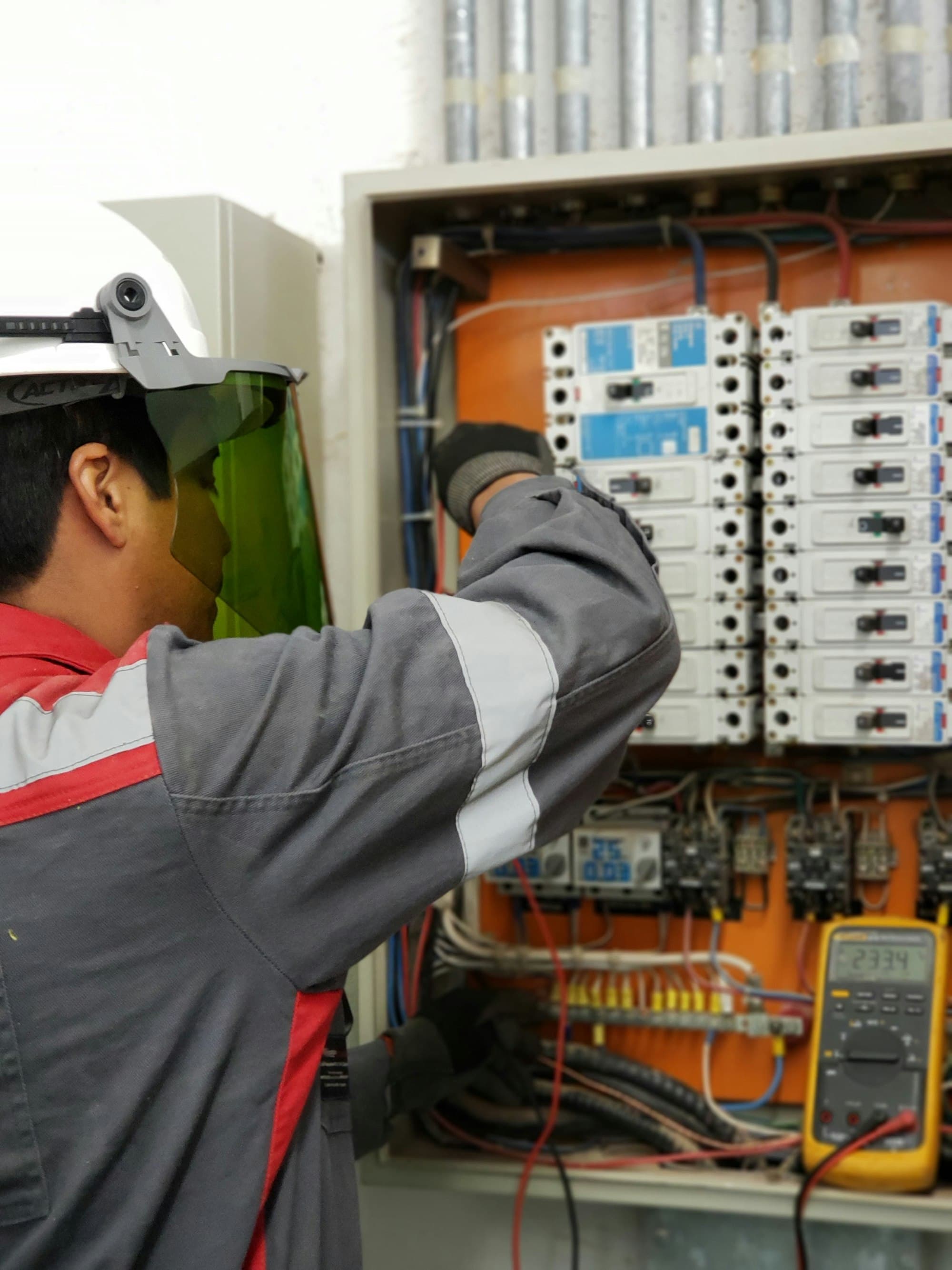 Technician testing a control panel with a multimeter