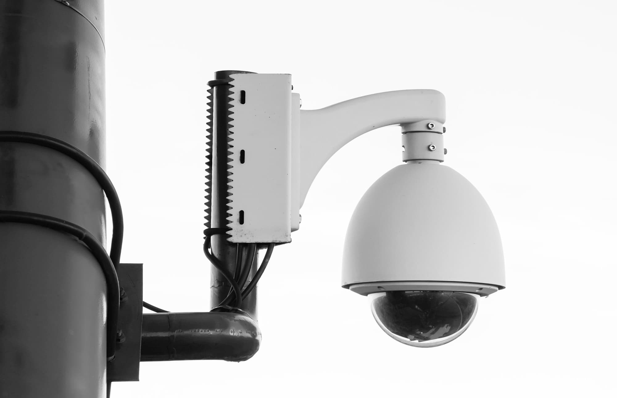 White PTZ dome security camera mounted on a pole